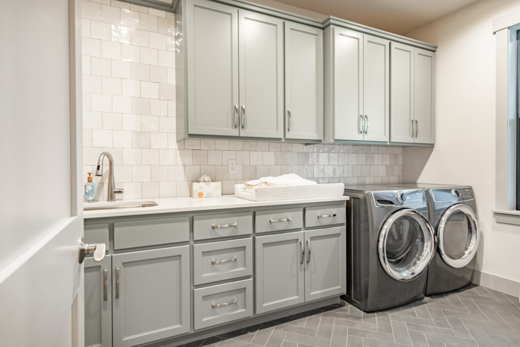 Beautiful home painted white with a modern farmhouse vibe. Bathroom powder room and laundry room all with light grey cabinets and warm wood tones.